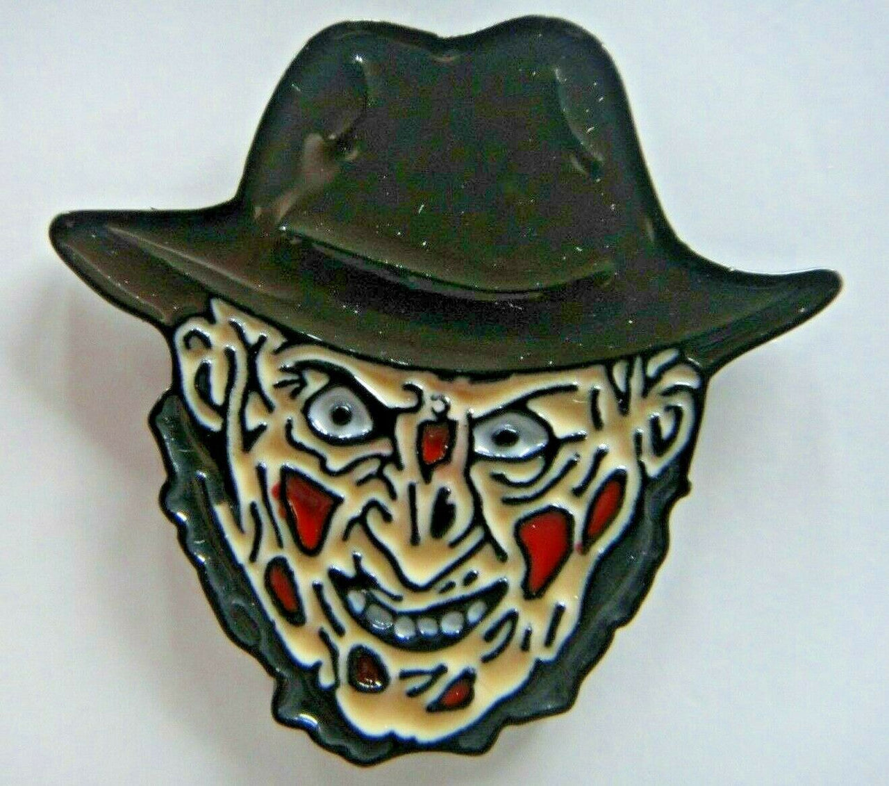 1 3/8" inches wide, a new Nightmare on Elm Street "Freddy Evil Face" enamel pin with a metal post and rubber back. New.  

Please note we will always combine shipping on like items.  Any additional patch or pin will ship for 50 cent per item.  Any additional payment will be reimbursed to your Paypal account.  Thank You.