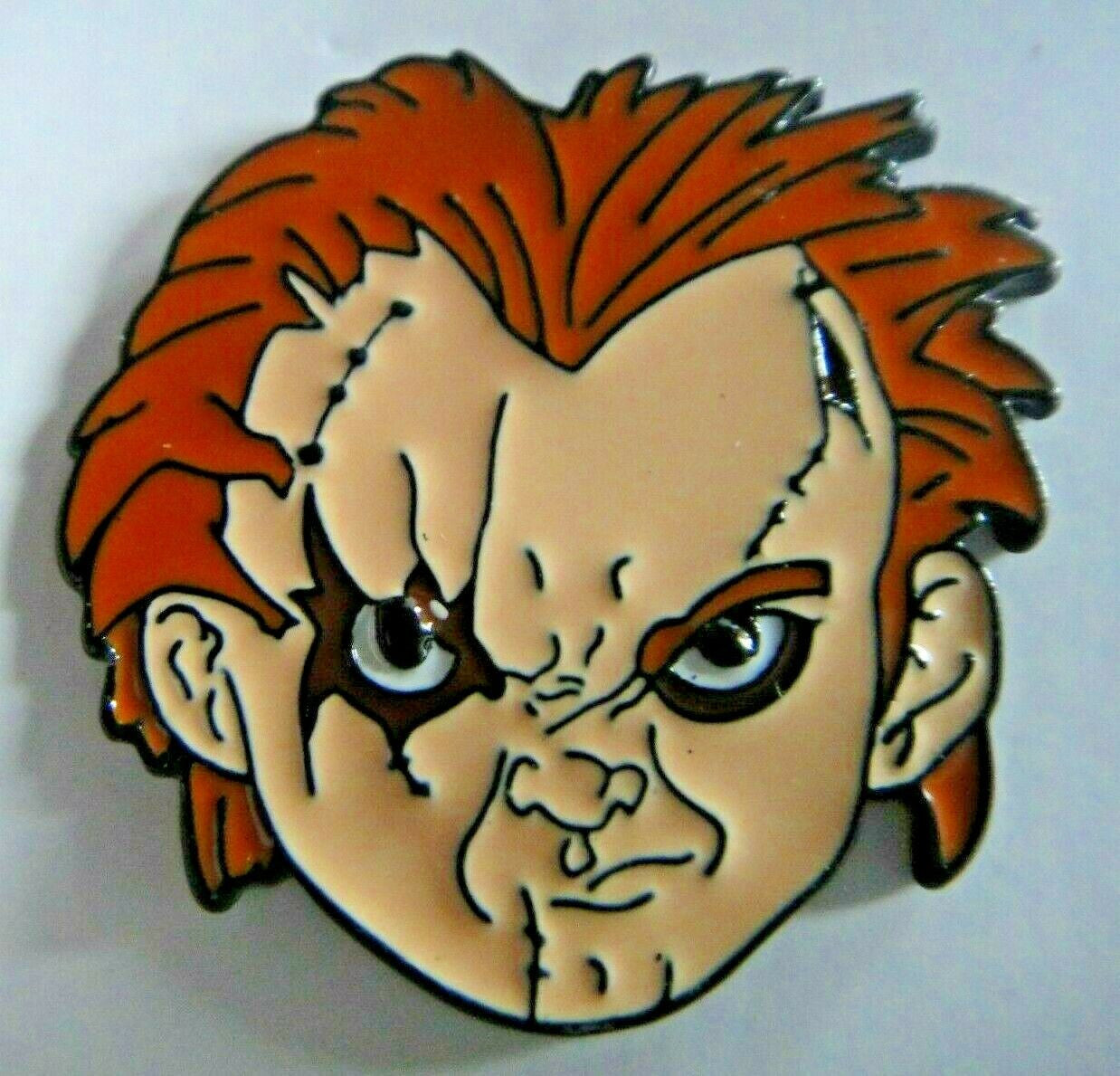 1. 1/2" inches tall, a new Child's Play "Chucky's Face" enamel pin with a metal post and rubber back. New.  

Please note we will always combine shipping on like items.  Any additional patch or pin will ship for 50 cent per item.  Any additional payment will be reimbursed to your Paypal account.  Thank You.