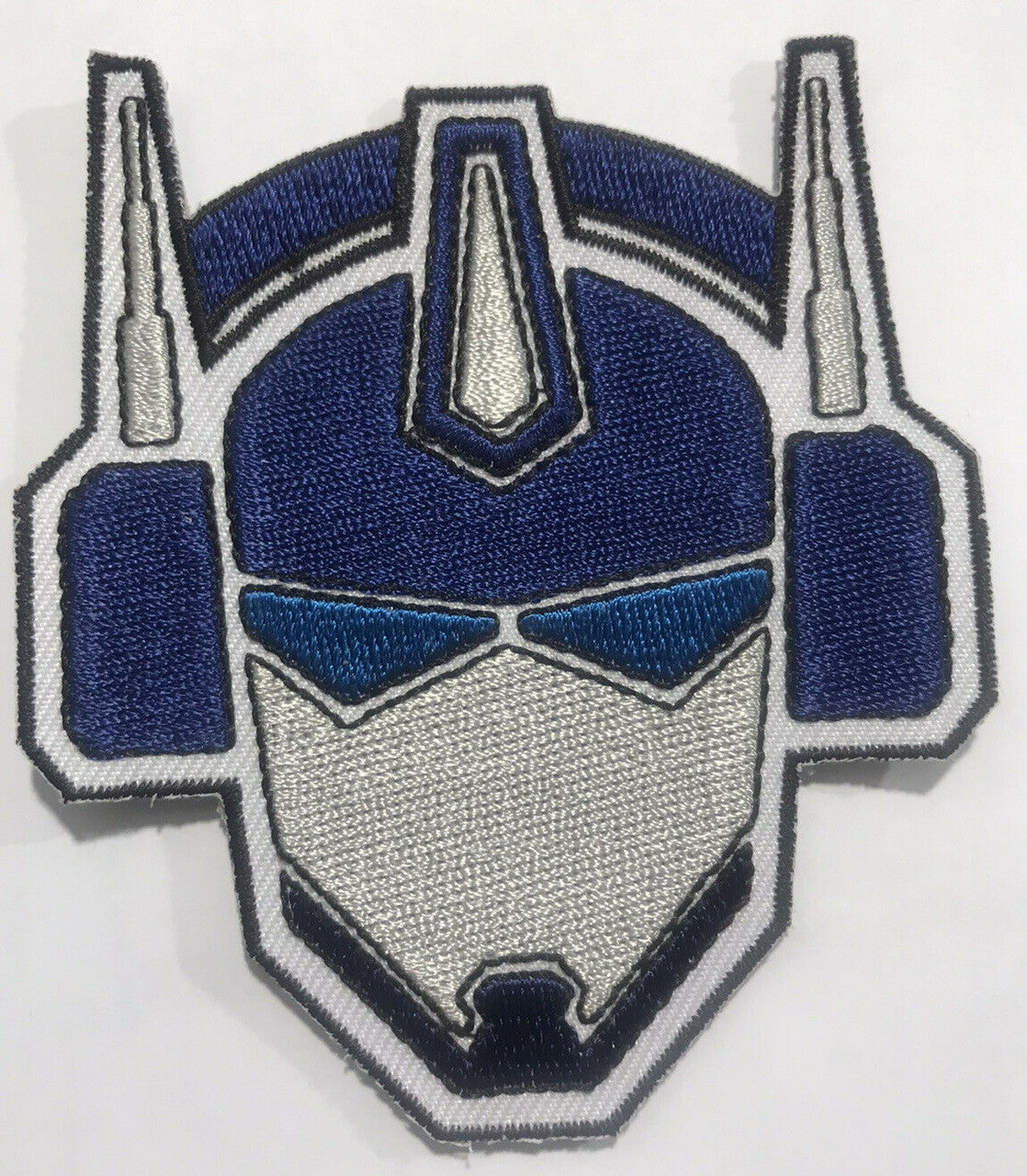 3.5 inches tall, a new Transformers "Bot Face" embroidered patch. Sew or iron on. New.

Please note we will always combine shipping on like items.  Any additional patch or pin will ship for 50 cent per item.  Any additional payment will be reimbursed to your Paypal account.  Thank You.