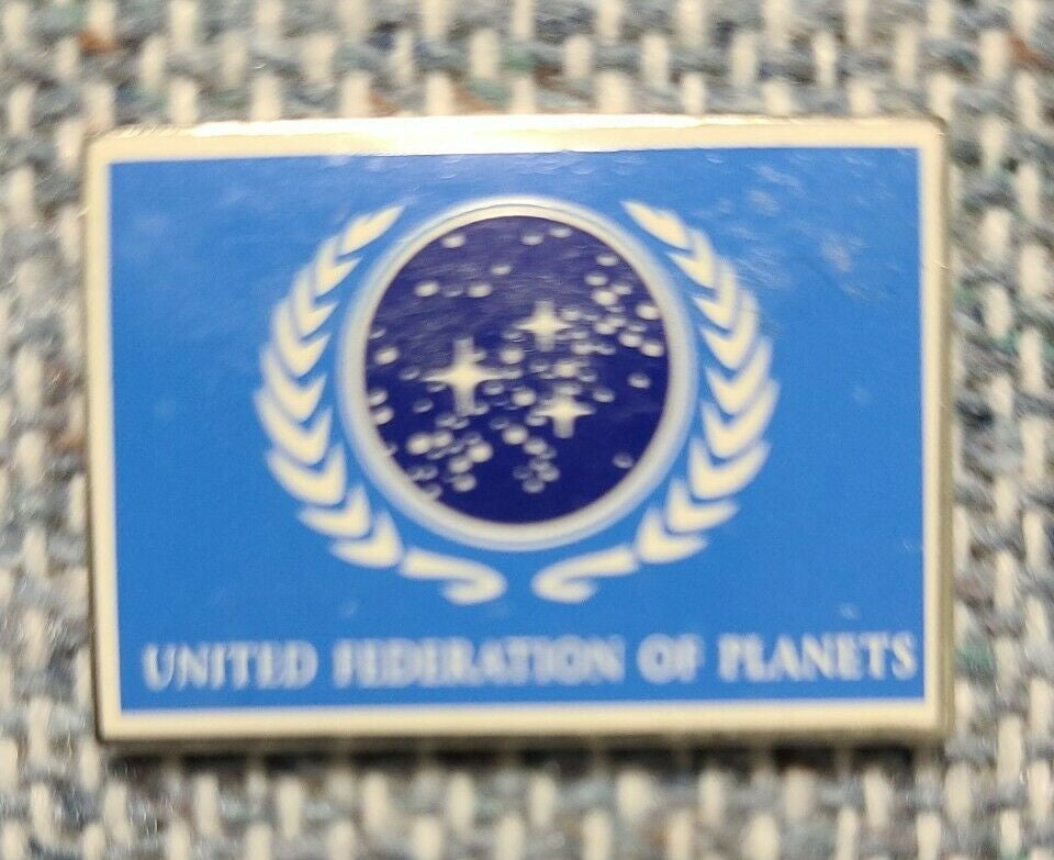 1. 1/4 inch wide, a new Star Trek United Federation of Planets Blue Flag enamel pin with post and clutch.  

Please note we will always combine shipping on like items.  Any additional patch or pin will ship for 50 cent per item.  Any additional payment will be reimbursed to your Paypal account.  Thank You.