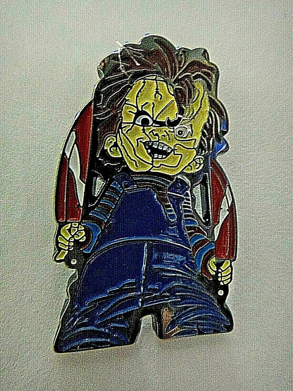 1. 1/2" inches tall, a new Child's Play "Chucky" enamel pin with a metal post and rubber back. New.  

Please note we will always combine shipping on like items.  Any additional patch or pin will ship for 50 cent per item.  Any additional payment will be reimbursed to your Paypal account.  Thank You.