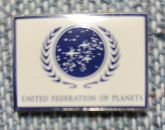 1. 1/4 inch wide, a new Star Trek United Federation of Planets White Flag enamel pin with post and clutch. 

Please note we will always combine shipping on like items.  Any additional patch or pin will ship for 50 cent per item.  Any additional payment will be reimbursed to your Paypal account.  Thank You.